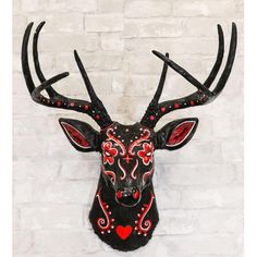 a black deer head with red hearts on it's antlers