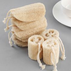 three rolls of toilet paper sitting on top of a table next to a cup and saucer