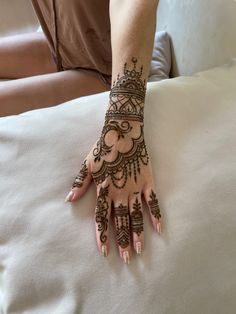 a woman's hand with henna tattoos on it