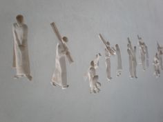 several pieces of paper are hanging on the wall next to each other, with one person holding a stick