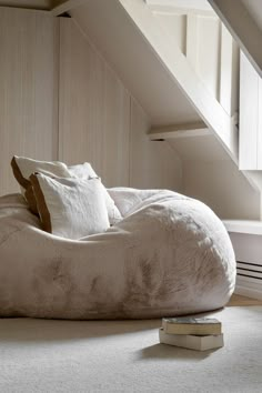 a bean bag chair sitting on top of a floor next to a stack of books