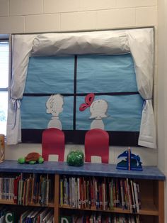 two children looking at each other through the window in front of bookshelves and windows