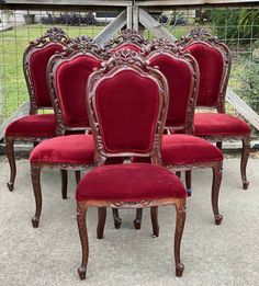 a set of six chairs with red velvet upholstered seats