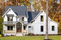 a white house in the fall with lots of trees