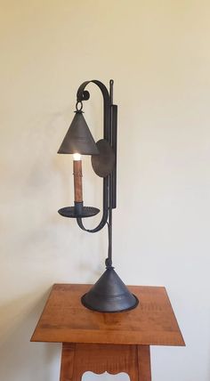 a table with a lamp on top of it and a wall light attached to the side