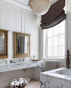 a bathroom with marble counter tops and two mirrors on the wall above the bathtub