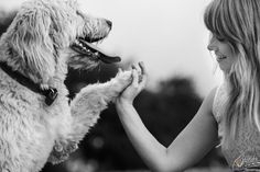 a woman is holding her dog's paw while it looks at the other side