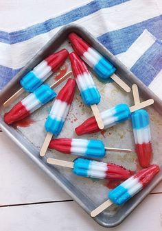 red, white and blue marshmallow pops on a baking pan with a towel