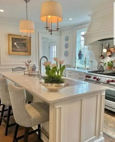 a large kitchen with an island in the middle and two chairs at the counter top