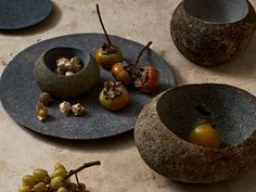 some fruits and vegetables are in bowls on a table