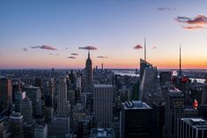 the sun is setting over new york's skyline as seen from top of the rock