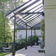 an outdoor patio area with tables, chairs and a pergolated roof over it