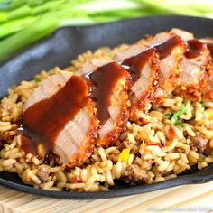 some meat and rice on a black plate