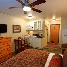 a bed room with a neatly made bed and a flat screen tv