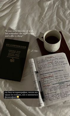 a cup of coffee and a book on a bed