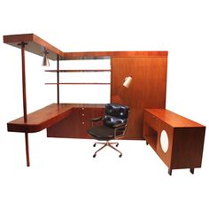 an office desk with a chair and shelving unit in the corner, on white background