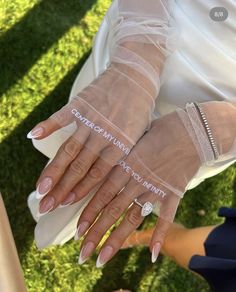 a woman with her hands wrapped around the wrist of another person wearing white gloves and holding an object