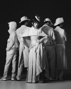 a group of people standing next to each other in front of a black and white photo