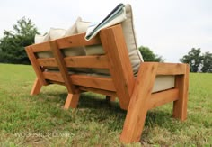 a wooden bench sitting on top of a lush green field