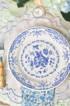 a blue and white plate sitting on top of a table next to a napkin holder