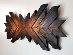 a wooden wall hanging with an arrow design on it