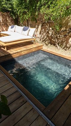 an outdoor hot tub in the middle of a wooden decked area with chaise lounges