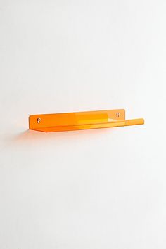 an orange plastic object on a white surface