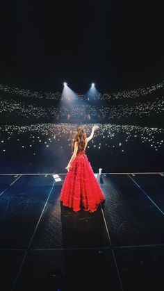 a woman in a red dress standing on a stage