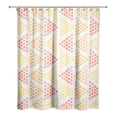 an orange and yellow shower curtain with polka dots on it, hanging from a metal rod