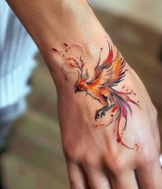 a woman's hand with a bird tattoo on it