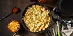 a skillet filled with macaroni and cheese next to other cooking utensils