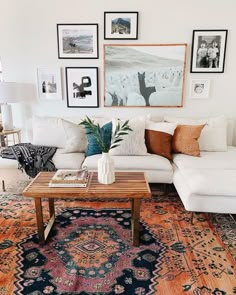 a living room filled with furniture and pictures on the wall above it's glass coffee table