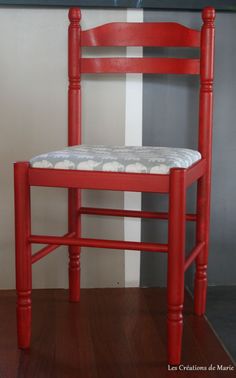 a red chair sitting in front of a wall