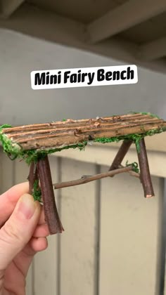 a miniature fairy bench made out of sticks and moss with the words mini fairy bench above it