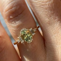 a woman's hand with a yellow and white diamond ring on top of it