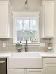 a white kitchen sink sitting under a window next to a dishwasher and oven