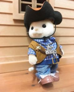 a small stuffed animal wearing a hat and overalls