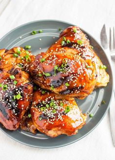 three pieces of chicken covered in sesame seeds on a plate