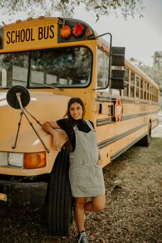 a woman standing next to a school bus