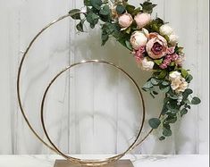 a metal circle with flowers and greenery on it