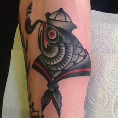 a man's arm with a fish tattoo on it and a hook in the middle