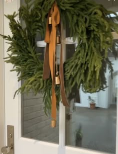 a wreath hanging on the front door of a house that says, put my mom's wreath up too