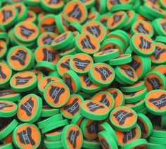 many green and orange buttons with black lettering on them are stacked together in the shape of an arrow