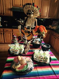 a table topped with lots of food and skeleton figurines on top of it