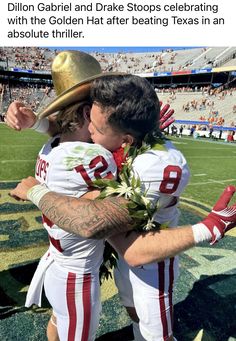 two football players hugging each other on the field