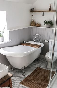 a white bath tub sitting in a bathroom next to a toilet