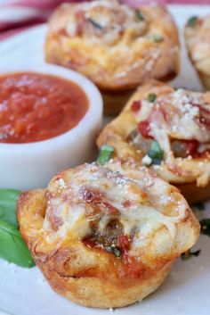 mini pizzas with sauce and spinach leaves on a plate