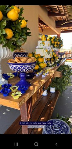 a table topped with blue and white dishes filled with lemons