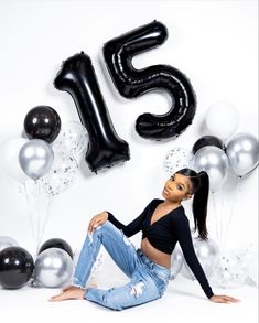 a woman sitting in front of balloons and numbers