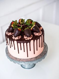 a chocolate covered cake with strawberries on top and drizzled in chocolate